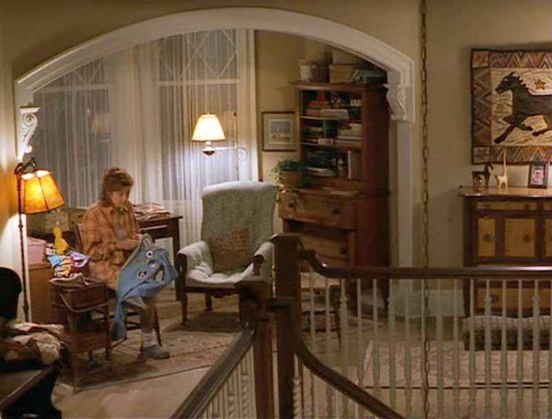 Susan Sarandon sits sewing on the landing