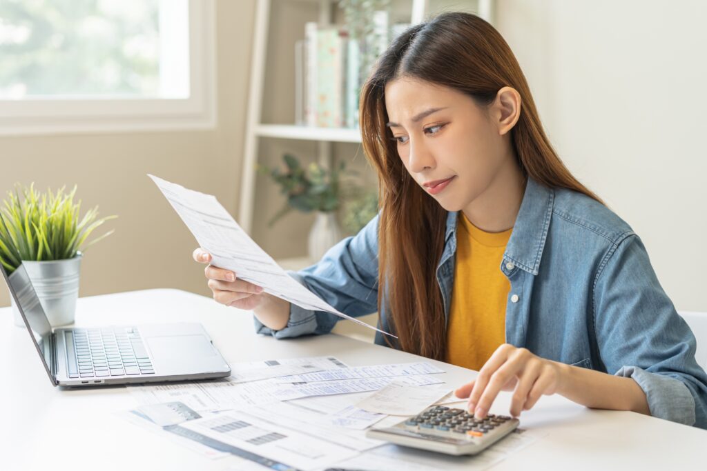 A stressed woman with a calculator | Where to get a $500 loan