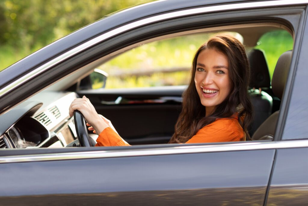 Happy woman driving | How to lease a car with bad credit