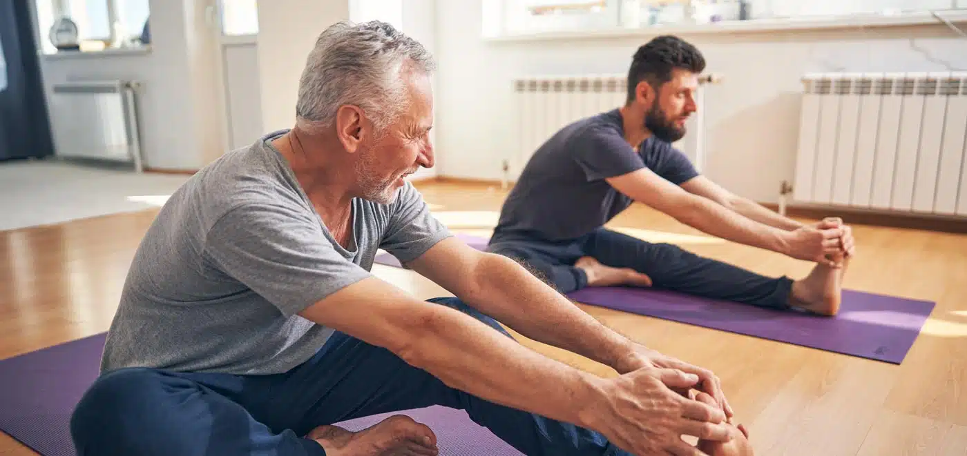 Two people working on improving their physical condition by stretching