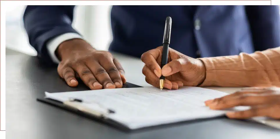 A person signs a legal document at a long term disability attorney's office